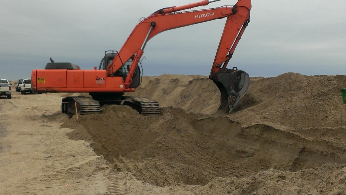 Excavator digging a trench on a GTA jobsite